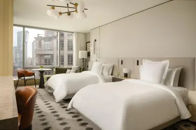 two beds in a hotel room with a large window at Four Seasons Hotel Toronto in Toronto