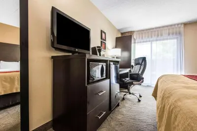 a hotel room with a television on a dresser with a bed at Comfort Inn in Owen Sound