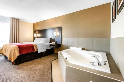 a hotel room with a bed and a bath tub at Comfort Inn in Owen Sound