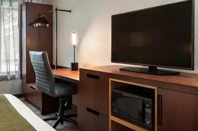 a hotel room with a desk with a television and a chair at Comfort Inn in Cambridge
