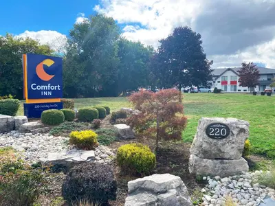 a sign for a conference inn with rocks and plants at Comfort Inn in Cambridge