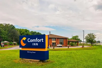 a sign in the grass in front of a building at Comfort Inn in Midland