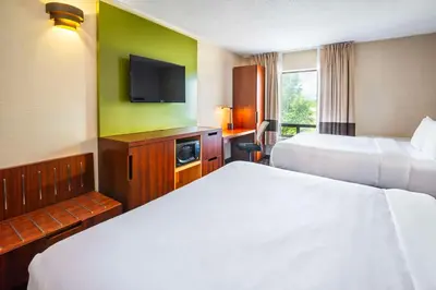 a hotel room with two beds and a flat screen tv at Comfort Inn in Midland