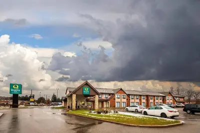 a parking lot with cars parked in front of a hotel at Quality Inn in Barrie