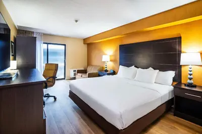 a hotel room with a large bed and a desk at Quality Inn in Barrie