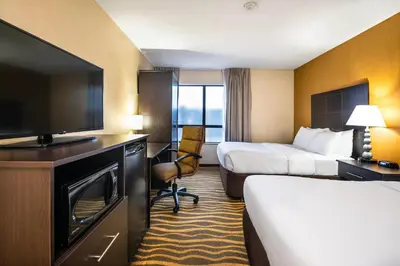 a hotel room with two beds and a flat screen tv at Quality Inn in Barrie