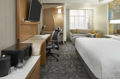 a hotel room with a bed and a desk at Courtyard by Marriott Oshawa in Oshawa