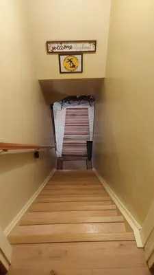 a staircase in a house with wooden floors and a sign at Private Apartment Close to Airport Toronto Pearson in Toronto