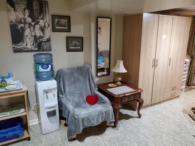 a room with a chair and a table with a heart pillow at Private Apartment Close to Airport Toronto Pearson in Toronto