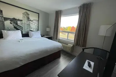 a hotel room with a large bed and a window at Super 8 by Wyndham Peterborough in Peterborough