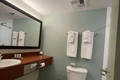 a bathroom with a toilet and a sink and a mirror at Super 8 by Wyndham Peterborough in Peterborough