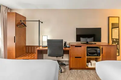 a hotel room with a desk and a television at Comfort Inn in Hamilton