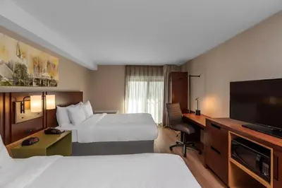 a hotel room with two beds and a flat screen tv at Comfort Inn in Hamilton