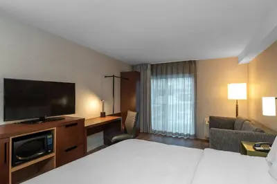 a hotel room with a bed and a flat screen tv at Comfort Inn in Hamilton