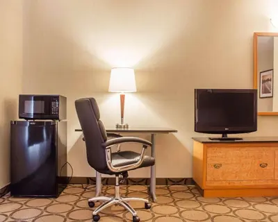 a room with a desk and a chair and a television at Comfort Inn in Brantford