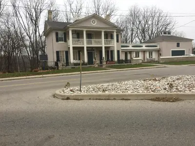 a house on the side of a road with a bird on the street at The Carriage House Flat - Downtown Paris Canada in Paris