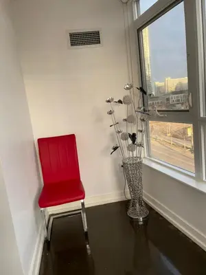 a red chair sitting in a room with a window at Toronto Downtown Luxurious Stylish 3 Bedroom 3 Bath 2 Balconies near Rogers Centre lakeview condo in Toronto