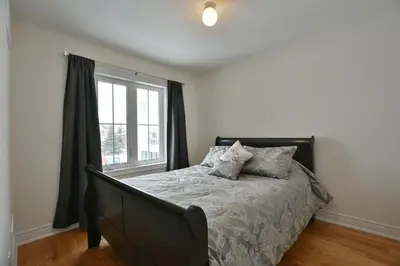 a bedroom with a bed and a window at New Blue Mountain Village Snowbridge Executive Townhome Sleeps 10 with Outdoor Pool and Shuttle in Nottawa
