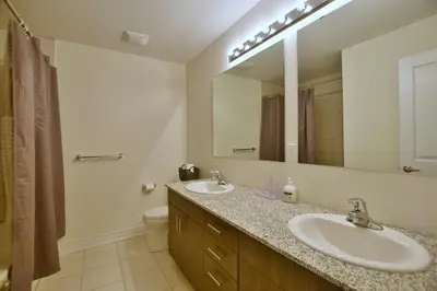 a bathroom with two sinks and a large mirror at New Blue Mountain Village Snowbridge Executive Townhome Sleeps 10 with Outdoor Pool and Shuttle in Nottawa