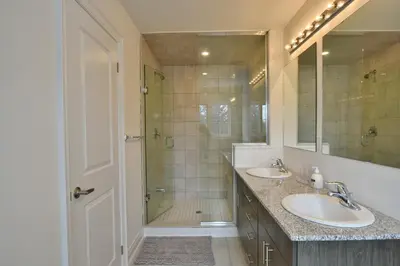 a bathroom with two sinks and a shower at New Blue Mountain Village Snowbridge Executive Townhome Sleeps 10 with Outdoor Pool and Shuttle in Nottawa