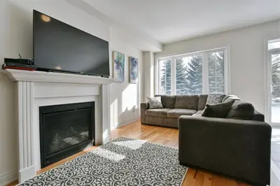 a living room with a couch and a fireplace at New Blue Mountain Village Snowbridge Executive Townhome Sleeps 10 with Outdoor Pool and Shuttle in Nottawa