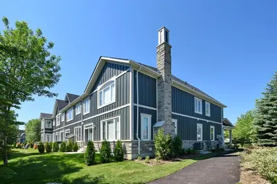 a large black house with a chimney at New Blue Mountain Village Snowbridge Executive Townhome Sleeps 10 with Outdoor Pool and Shuttle in Nottawa