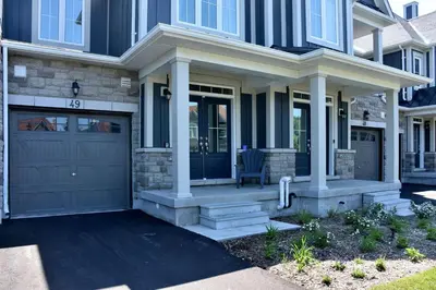 a house with a front door and a garage at New Blue Mountain Village Snowbridge Executive Townhome Sleeps 10 with Outdoor Pool and Shuttle in Nottawa