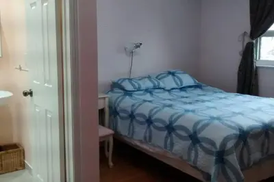 a bedroom with a bed with blue sheets and a window at Private Room near Airport in Mississauga