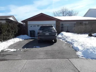 a minivan parked in a driveway in front of a house at Private Room near Airport in Mississauga