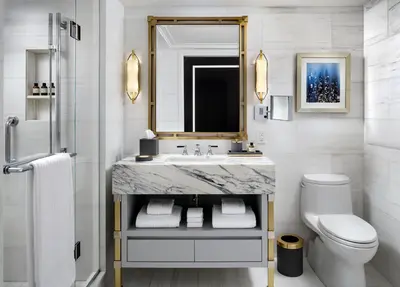 a bathroom with a sink and a toilet and a mirror at Fairmont Royal York Gold Experience in Toronto