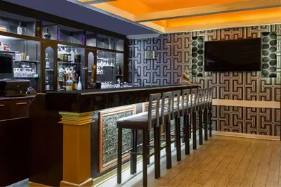a bar with a bunch of stools in a room at Howard Johnson by Wyndham Niagara Falls in Niagara Falls