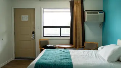 a bedroom with a bed and a window and a door at Howard Johnson by Wyndham Niagara Falls in Niagara Falls