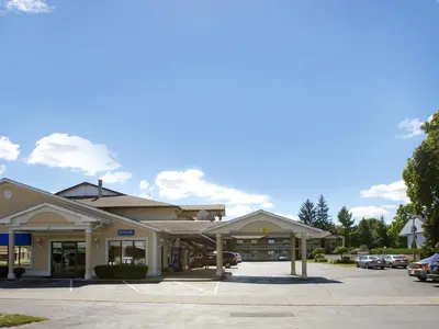 a building with cars parked in a parking lot at Howard Johnson by Wyndham Niagara Falls in Niagara Falls