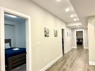 a bedroom with a bed and a hallway at Charming, Comfortable Bsmt Apartment in Pickering in Pickering