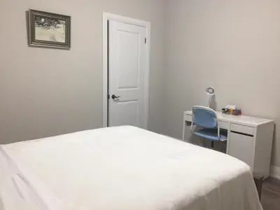 a bedroom with a bed and a desk and a chair at Charming, Comfortable Bsmt Apartment in Pickering in Pickering