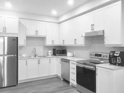 a kitchen with white cabinets and stainless steel appliances at Charming, Comfortable Bsmt Apartment in Pickering in Pickering