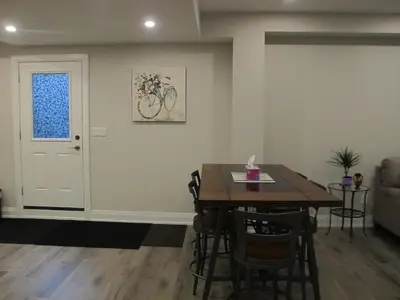 a dining room with a table and a bike on the wall at Charming, Comfortable Bsmt Apartment in Pickering in Pickering