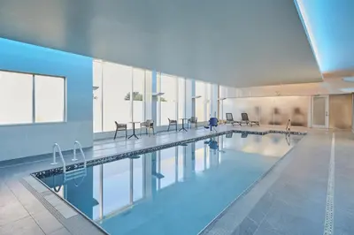 a large swimming pool with tables and chairs in a building at Hyatt Place Toronto Mississauga and Luxe Convention Centre in Mississauga