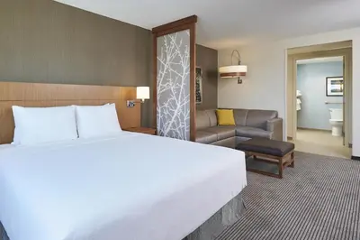 a bedroom with a large bed and a living room at Hyatt Place Toronto Mississauga and Luxe Convention Centre in Mississauga