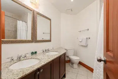a bathroom with two sinks and a toilet and a mirror at Blue Mountain-Luxurious BlueSki George Chalet, Hot Tub, Pool, Gas Fireplace in Blue Mountains