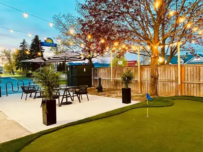 a patio with a table and chairs and a putting green at Days Inn by Wyndham Stouffville in Stouffville