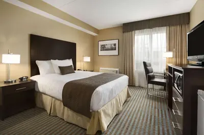 a hotel room with a bed and a television at Days Inn by Wyndham Stouffville in Stouffville