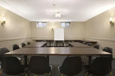 a conference room with tables and chairs and a whiteboard at Days Inn by Wyndham Stouffville in Stouffville
