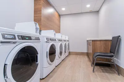 a laundry room with a row of washing machines at TownePlace Suites by Marriott Brantford and Conference Centre in Brantford
