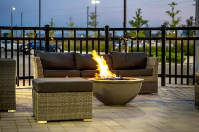 a fire pit with two couches and a fire bowl at TownePlace Suites by Marriott Brantford and Conference Centre in Brantford