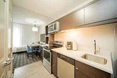 a kitchen with a sink and a table at TownePlace Suites by Marriott Brantford and Conference Centre in Brantford