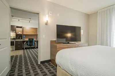 a hotel room with a bed and a flat screen tv at TownePlace Suites by Marriott Brantford and Conference Centre in Brantford