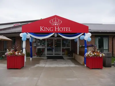a king hotel entrance with a red and blue canopy at King Hotel in Palmerston