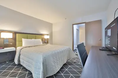a hotel room with a bed and a desk with a computer at King Hotel in Palmerston