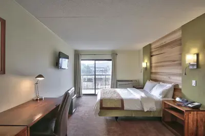 a hotel room with a bed with a desk and a window at Blue Mountain Resort Inn in Blue Mountains
